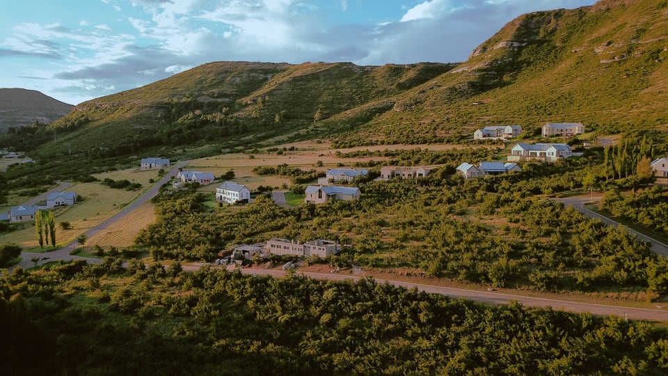 Aerial view of Clarens Mountain Estate, sandstone cliffs and mountain road