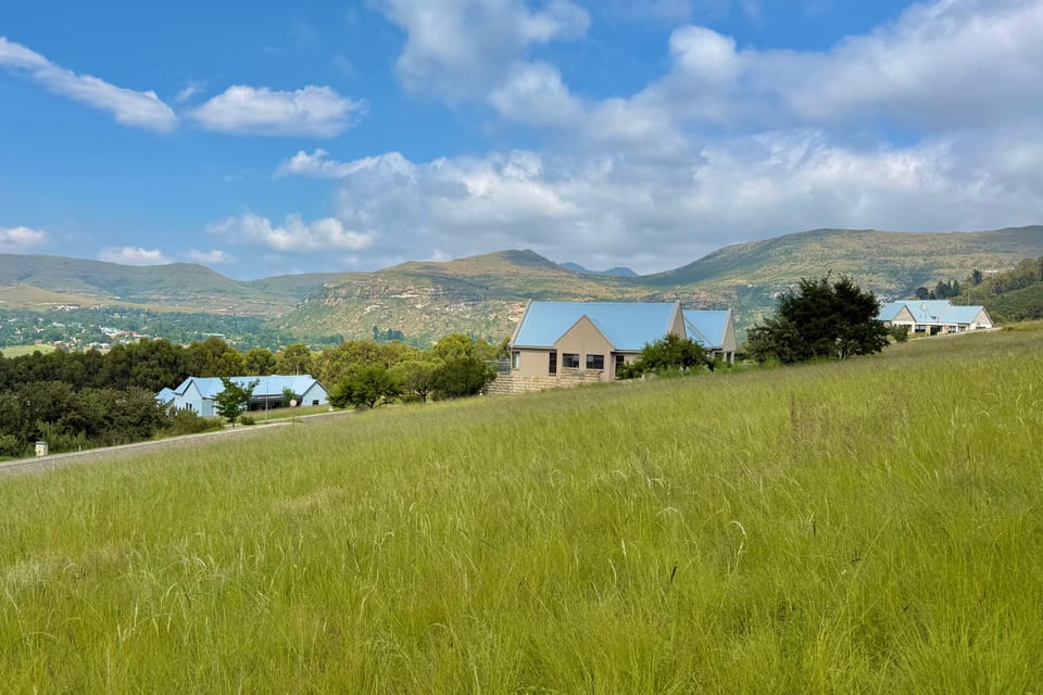 Estate homes set well apart across open meadow, with the mountains behind