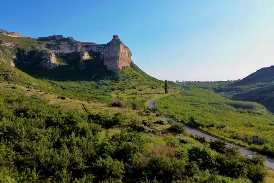 The sandstone buttress above Clarens Mountain Estate, with the road curving through the veld below